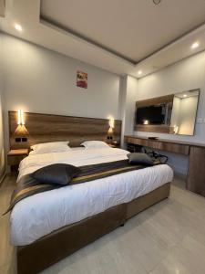 1 dormitorio con 1 cama grande y TV de pantalla plana en Park Plus Served Apartments, en Medina