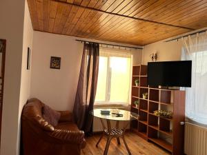 a living room with a glass table and a tv at Ambra Room's in Braşov +29 photos