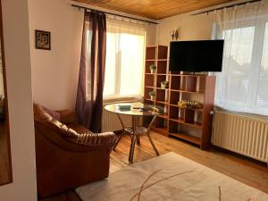 a living room with a table and a television at Ambra Room's in Braşov