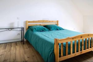 a bedroom with a wooden bed with blue pillows at MAISON CREUZIER - Vichy à 5min - Jardin - BBQ - Calme in Creuzier-le-Vieux