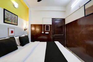 um quarto com uma cama e uma porta de madeira em Green Park Residency em Nova Deli