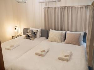 duże białe łóżko z dwoma białymi ręcznikami w obiekcie Lido North Shinagawa w Tokio