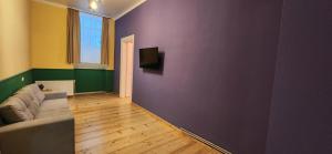 un soggiorno con divano e parete viola di Friends - Your Cosy Apartment in the Center a Tbilisi City