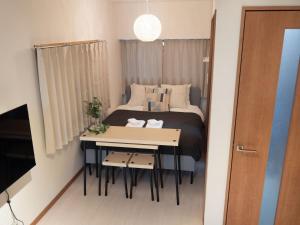 niewielka sypialnia z łóżkiem i stołem w obiekcie Lido North Shinagawa w Tokio