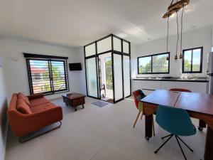 a living room with a dining room table and chairs at Modern - Wan Pipel with Terrace in Paramaribo