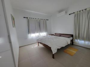 een slaapkamer met een bed in een witte kamer bij Modern - Wan Pipel with Terrace in Paramaribo