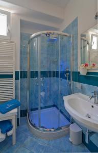a blue bathroom with a shower and a sink at Hotel Imperamare in Ischia