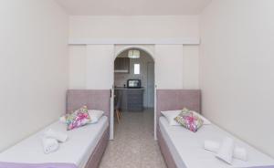 two beds in a room with a kitchen at Kamara Apartments in Alikanas