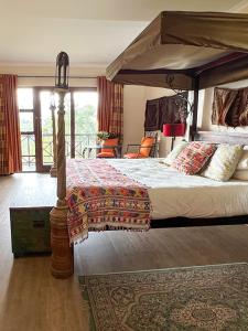 een slaapkamer met een groot bed met een baldakijn bij Far Hills Country Hotel in George