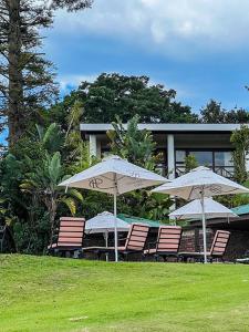 een groep stoelen en parasols voor een gebouw bij Far Hills Country Hotel in George