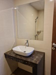 a bathroom with a white sink and a mirror at 1 Bedroom Apartment nagoya thamrin city batam in Nagoya