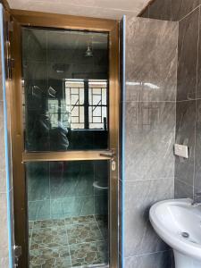 a shower with a glass door in a bathroom at Capricorn Lake Cottage in Cape Maclear