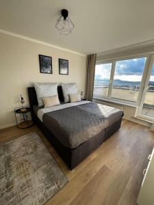 a bedroom with a large bed with a large window at Charmante Penthouse - Therme Badewelt - Museum in Sinsheim Hoffenheim in Sinsheim