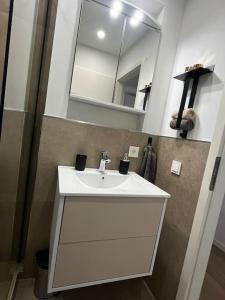 een badkamer met een witte wastafel en een spiegel bij Charmante Penthouse - Nahe Badewelt - Hoffenheim Stadion in Sinsheim