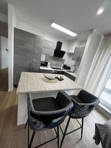 een keuken met 2 stoelen en een aanrecht in een keuken bij Charmante Penthouse - Nahe Badewelt - Hoffenheim Stadion in Sinsheim