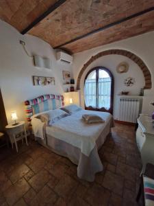 - une chambre avec un grand lit et une fenêtre dans l'établissement Casa Donella, à Poggibonsi