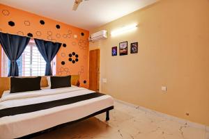 - une chambre avec un grand lit aux murs orange dans l'établissement Emerald Inn, à Bhubaneswar