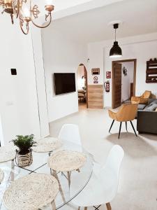sala de estar con mesa de cristal y sillas blancas en Violeta Suite en Madrid