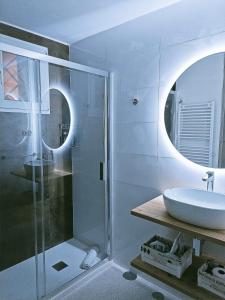 y baño con ducha acristalada y lavamanos. en Violeta Suite en Madrid