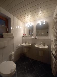 bagno con 2 lavandini, servizi igienici e specchi di Ferienwohnung am Stießberg a Oberstaufen