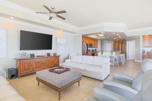 ein Wohnzimmer mit weißen Möbeln und einem Flachbild-TV in der Unterkunft Phoenix West 609 condo in Orange Beach