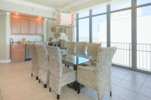 ein Esszimmer mit Tisch und Korbstühlen in der Unterkunft Phoenix West 609 condo in Orange Beach