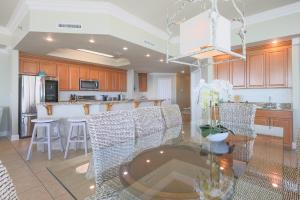 eine Küche mit einem Glastisch und Stühlen im Zimmer in der Unterkunft Phoenix West 609 condo in Orange Beach