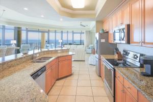 eine große Küche mit Blick auf ein Wohnzimmer in der Unterkunft Phoenix West 609 condo in Orange Beach