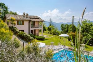 een villa met een zwembad en een huis bij La Panoramica Da Stroppa in Acqualagna