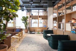 a living room with couches and chairs and plants at Noli Otaniemi in Espoo