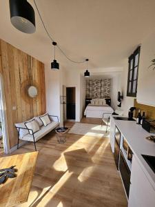 La Maison Grivolas Appartements et Maison d'hôtes في أفينيون: مطبخ وغرفة معيشة مع سرير في الخلفية