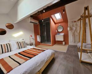 a bedroom with a large bed with orange walls at La Maison Grivolas in Avignon