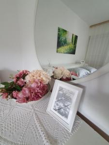 Ferienhaus Brice / Mostar في موستار: طاولة مع الزهور ومرآة في الغرفة
