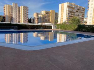 トレ・デル・マールにあるApartamento cerca de la playa, Torre Del Marの背景の建物を背景にした水のプール