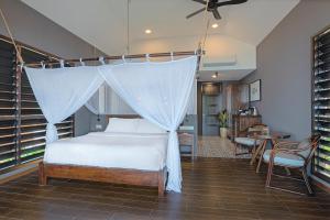um quarto com uma cama com mosquiteiro em The Boathouse Pulau Tioman em Ilha Tioman