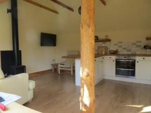 una cucina con un palo di legno in una stanza di Sycamore Cottage a Boat of Garten