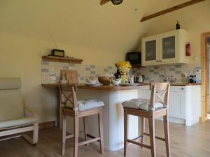 una cucina con bancone, due sedie e un tavolo di Sycamore Cottage a Boat of Garten