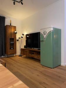 a living room with a refrigerator and a flat screen tv at Apartment Beletage Bad Harzburg in Bad Harzburg