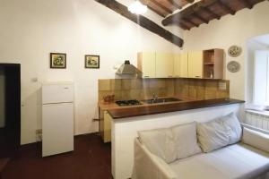 a kitchen with a couch and a sink in a room at Apartment in Sovicille with heating in Sovicille