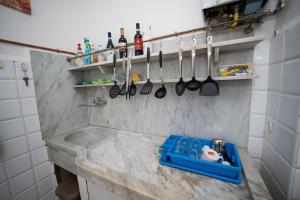 a kitchen with a counter with utensils on the wall at Stanza doppia con bagno e cucina in comune Genova in Genoa