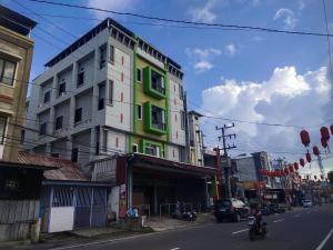 um edifício ao lado de uma rua da cidade em Capital O 93589 Hotel Wongso Syariah em Pangkal Pinang