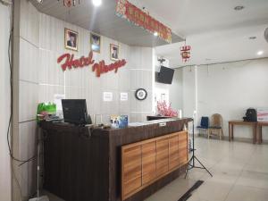 ein Restaurant mit einer Rezeption und einem Laptop darauf in der Unterkunft Capital O 93589 Hotel Wongso Syariah in Pangkalpinang