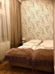 sypialnia z łóżkiem i tapetą w kwiaty w obiekcie Sands Sopot Apartments 1a w mieście Sopot