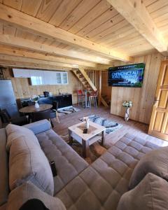 a living room with a large couch and a television at Vikendica Ivana in Livno