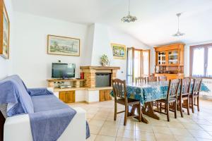 een woonkamer met een tafel en stoelen en een televisie bij La Panoramica Da Stroppa in Acqualagna