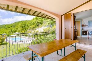een balkon met een houten tafel en uitzicht op de oceaan bij La Panoramica Da Stroppa in Acqualagna