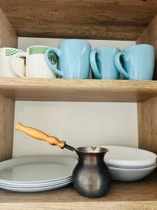 a shelf with a pot and cups and plates at Belveder Center Home in Ivano-Frankivsk