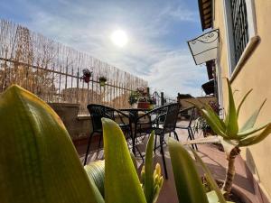 eine Terrasse mit Stühlen, Tischen und Pflanzen auf dem Balkon in der Unterkunft HomingPisa - Gemini One in Pisa