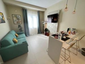 ein Wohnzimmer mit einem blauen Sofa und einer Küche in der Unterkunft HomingPisa - Gemini One in Pisa
