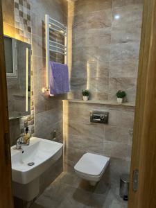 a bathroom with a white sink and a toilet at Appartement de la joie in El Aouina
